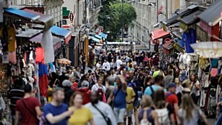 Des gens, principalement des touristes, se pressent dans une rue du quartier de Montmartre à Paris, le vendredi 9 août 2019. 