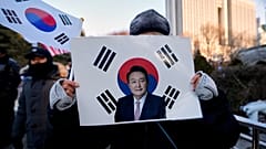 Güney Kore'de eski Devlet Başkanı Yoon Suk Yeol'un bir destekçisi, başkent Seul'de mahkeme önünde pankart tutuyor, 13 Ocak 2026.