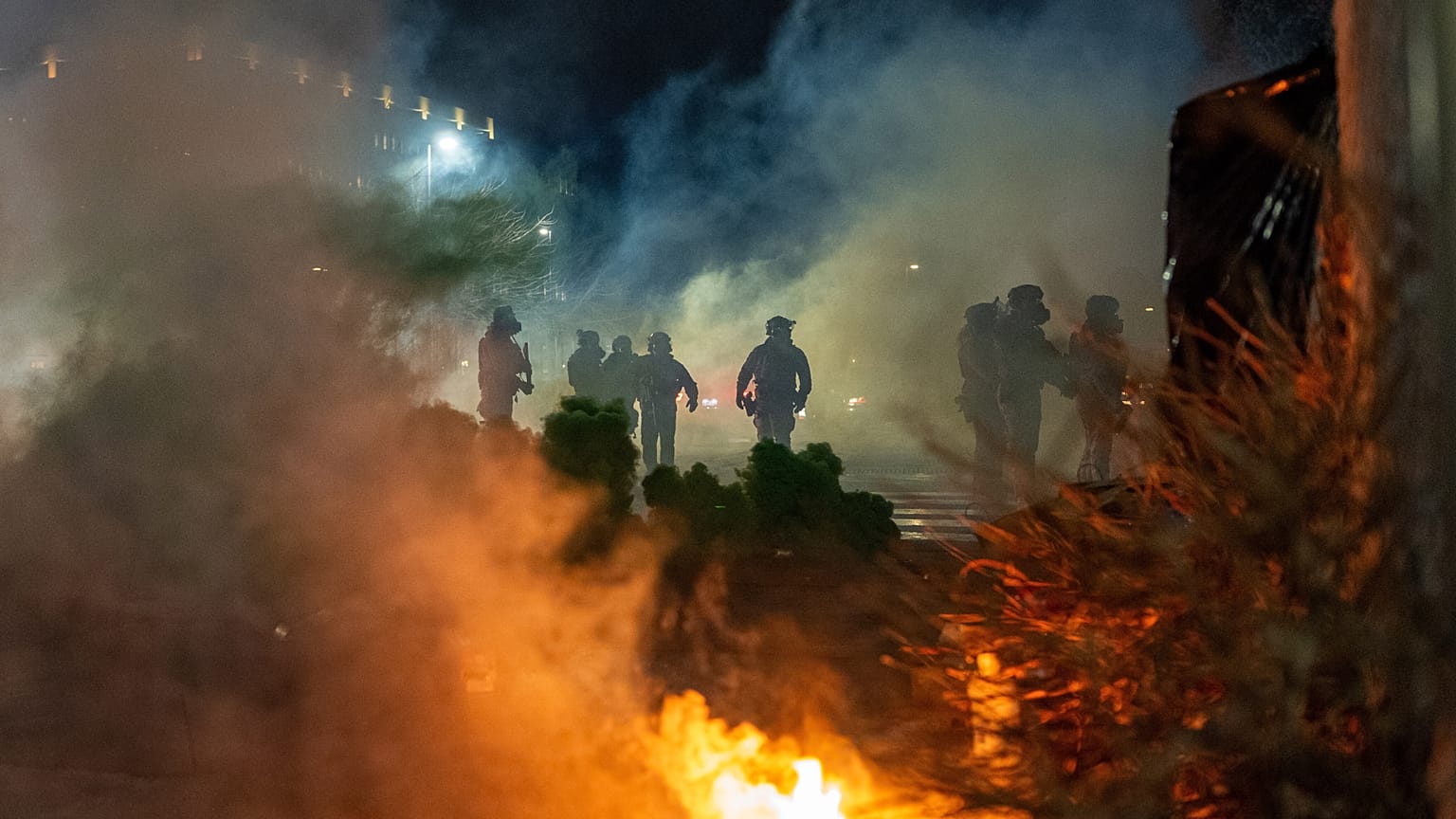 Des agents fédéraux de l'immigration devant le bâtiment fédéral Bishop Whipple après le déploiement de gaz lacrymogène, le lundi 12 janvier 2026, à Minneapolis, aux États-Unis