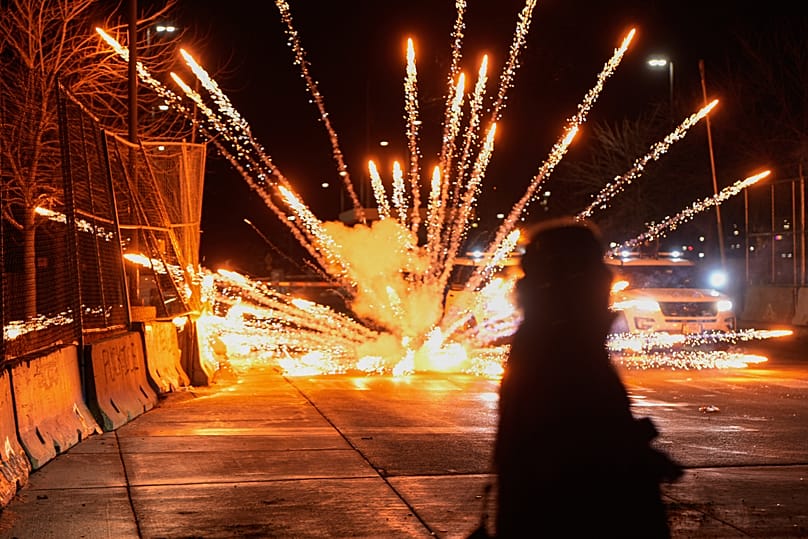 Des feux d'artifice sont tirés par des manifestants devant le bâtiment fédéral Bishop Henry Whipple, lundi 12 janvier 2026, à Minneapolis