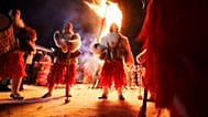 Bulgarische Kukeri-Tänzer versammeln sich um ein Lagerfeuer. Sie vollziehen das uralte Surva-Ritual.