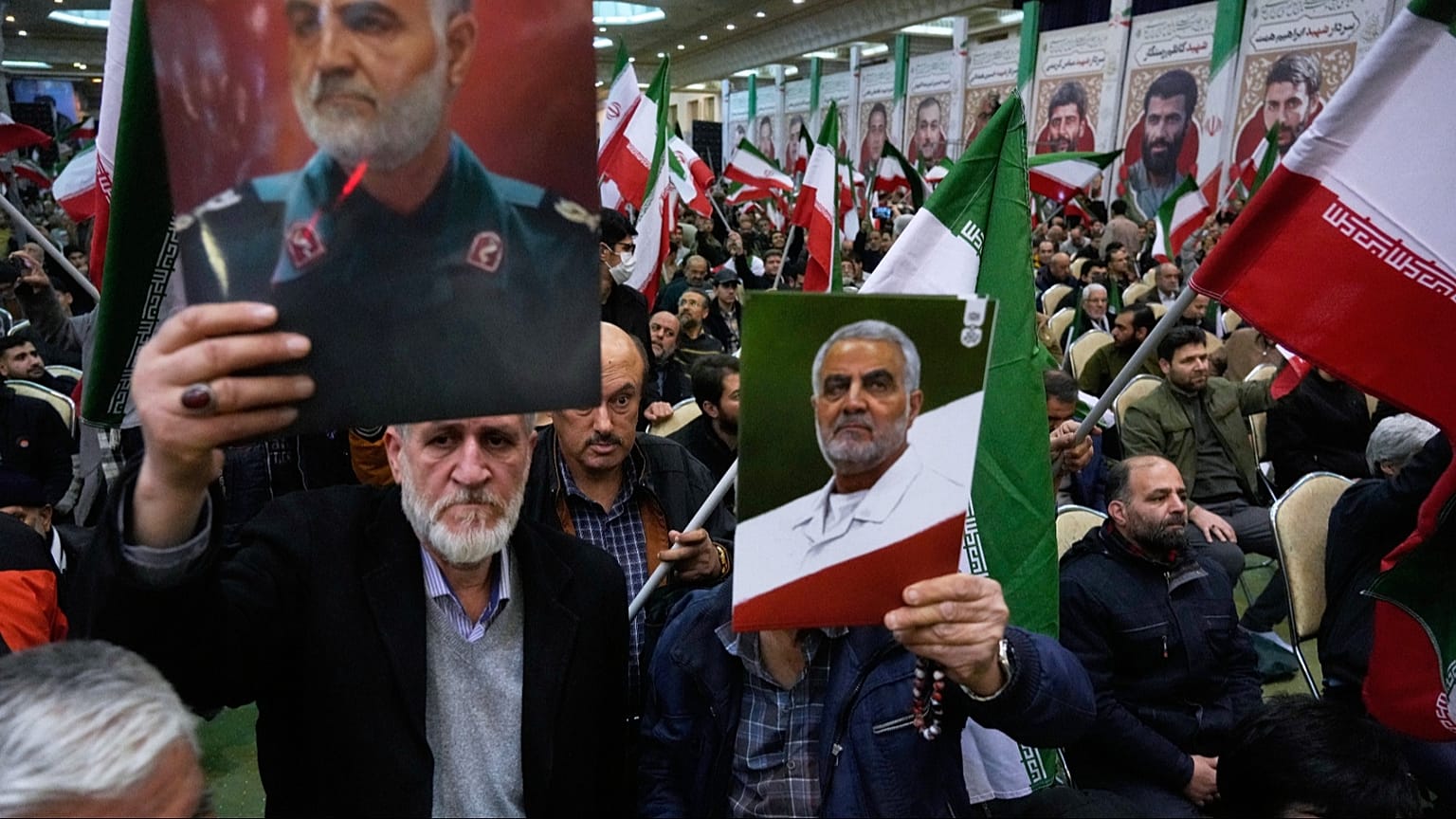 Two men hold up posters of the late commander of Iran's Revolutionary Guard expeditionary Quds Force, Gen. Qassem Soleimani, who was killed in a U.S. drone attack in 2020