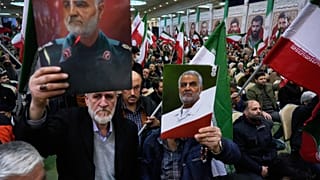 Two men hold up posters of the late commander of Iran's Revolutionary Guard expeditionary Quds Force, Gen. Qassem Soleimani, who was killed in a U.S. drone attack in 2020