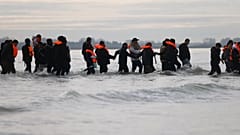 Μετανάστες σπρώχνουν μια μικρή βάρκα στην προσπάθειά τους να φτάσουν στο Ηνωμένο Βασίλειο, 6 Νοεμβρίου 2025