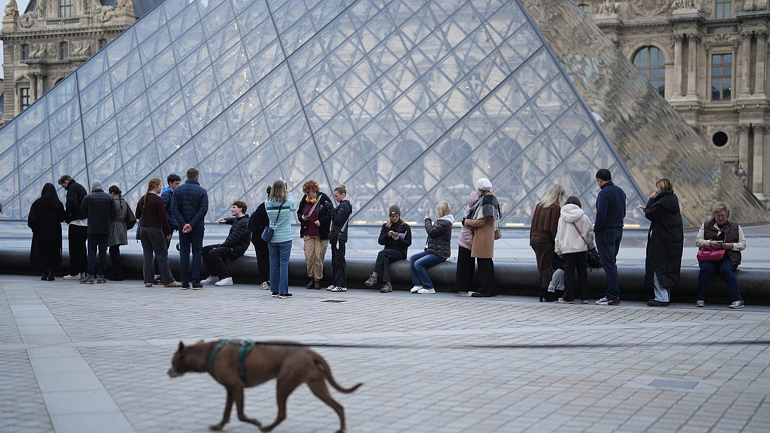 Des personnes attendent l'ouverture du musée du Louvre alors que les employés du musée votent pour prolonger leur grève, jeudi 18 décembre 2025 à Paris.  