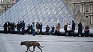 Des personnes attendent l'ouverture du musée du Louvre alors que les employés du musée votent pour prolonger leur grève, jeudi 18 décembre 2025 à Paris.  
