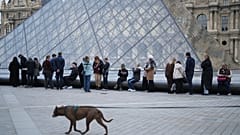 Paris'te 18 Aralık 2025 Perşembe günü, müze çalışanları grevi uzatmak için oy verirken insanlar Louvre Müzesi'nin açılışını bekliyor.