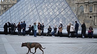Des personnes attendent l'ouverture du musée du Louvre alors que les employés du musée votent pour prolonger leur grève, jeudi 18 décembre 2025 à Paris.  