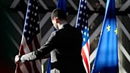 A worker adjusts the US and EU flags at the European Council building in Brussels, 4 April, 2023