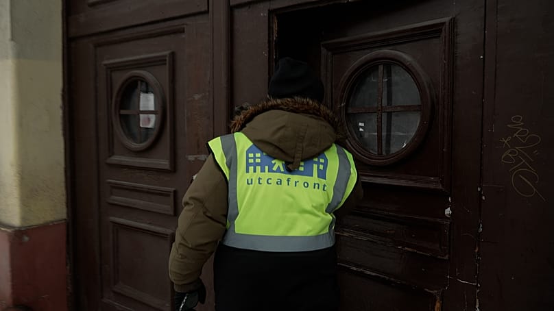 A baptisták krízisautójának munkatársa ellenőriz egy kapualjat Zuglóban