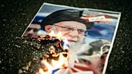 A burning image of the Ayatollah Ali Khamenei is seen during rally in Zurich, 13 January, 2026 