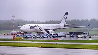 ARCHIVO- Coches de policía permanecen frente a un avión de Iran Air en el aeropuerto de Hamburgo en Hamburgo, Alemania, lunes 9 de octubre de 2023.