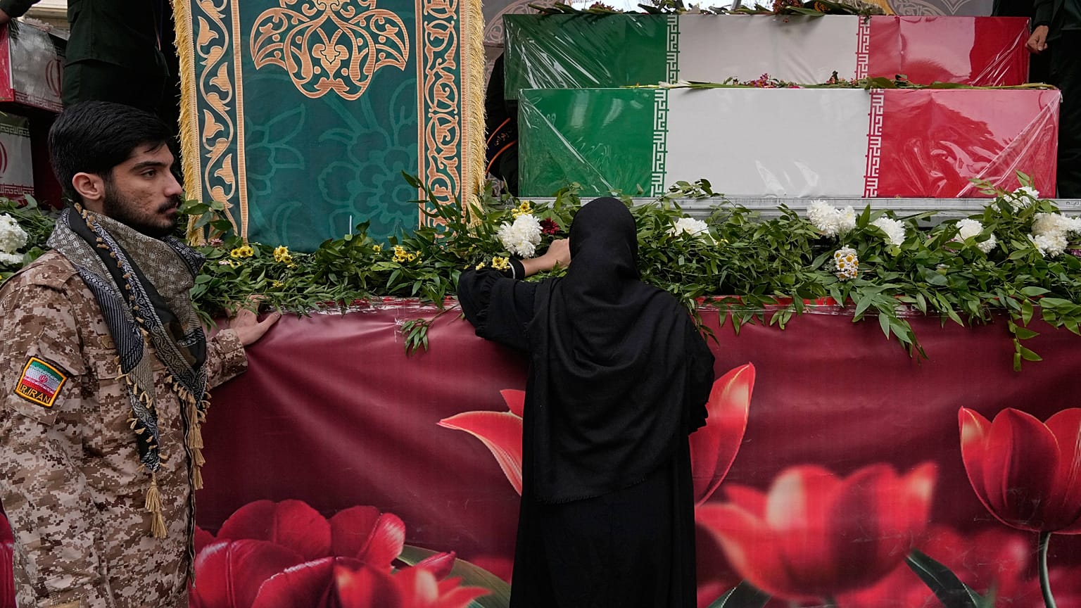 Una donna piange accanto alle bare di membri delle forze di sicurezza, morti durante le proteste antigovernative a Teheran (14 gennaio 2026)