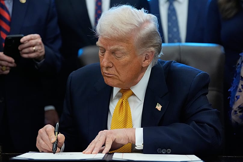 US President Donald Trump signs a bill in the Oval Office of the White House, 14 January, 2026