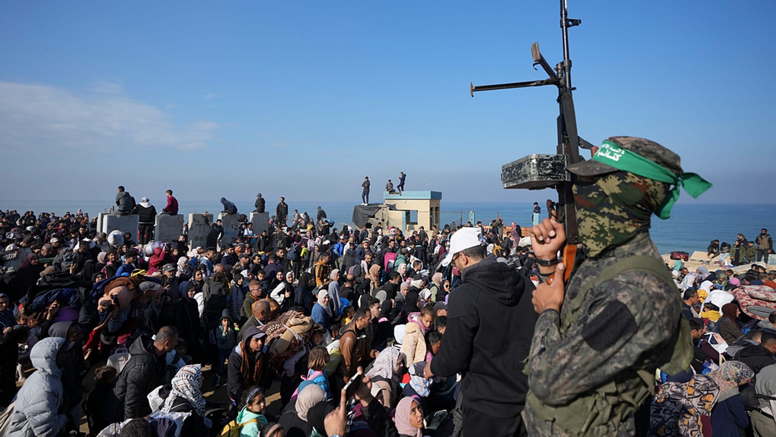 صورة تعبيرية_ مقاتل من حماس يرفع سلاحه بينما يعود الفلسطينيون النازحون إلى ديارهم في شمال قطاع غزة
