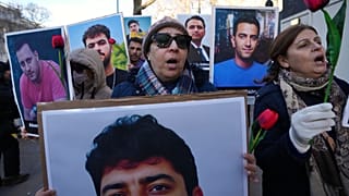 Varios manifestantes sostienen fotos de las víctimas mientras se manifiestan en apoyo a las protestas antigubernamentales en Irán desde Londres, el 14 de enero de 2026
