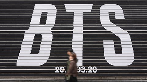 People walk by the huge letters of BTS at downtown Seoul, South Korea, Thursday, Jan. 15, 2026