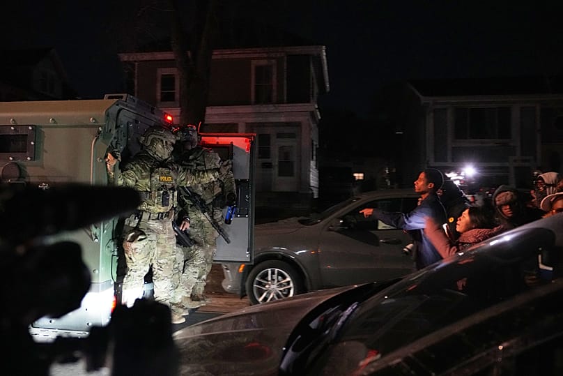 Protesters shout at law enforcement officers after a shooting on Wednesday, Jan. 14, 2026, in Minneapolis.