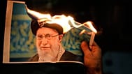 Manifestantes queman un cartel que representa al líder supremo de Irán, el ayatolá Alí Jamenei, durante una manifestación en Holon, Israel, el 14 de enero de 2026. 