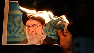 Manifestantes queman un cartel que representa al líder supremo de Irán, el ayatolá Alí Jamenei, durante una manifestación en Holon, Israel, el 14 de enero de 2026. 