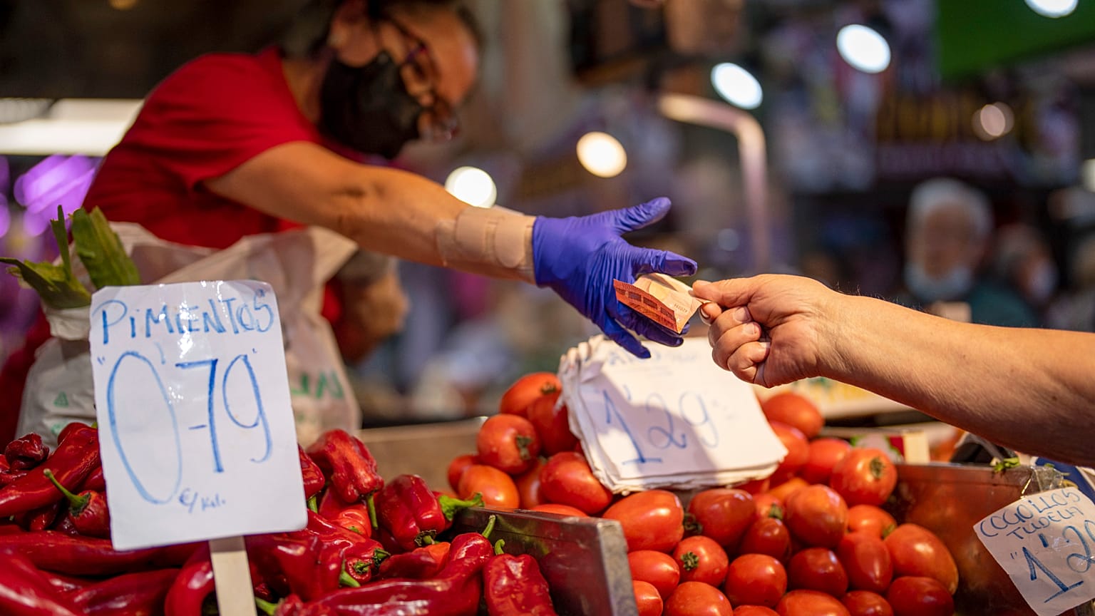 Un cliente paga verduras en el mercado de Maravillas de Madrid, el 12 de mayo de 2022.