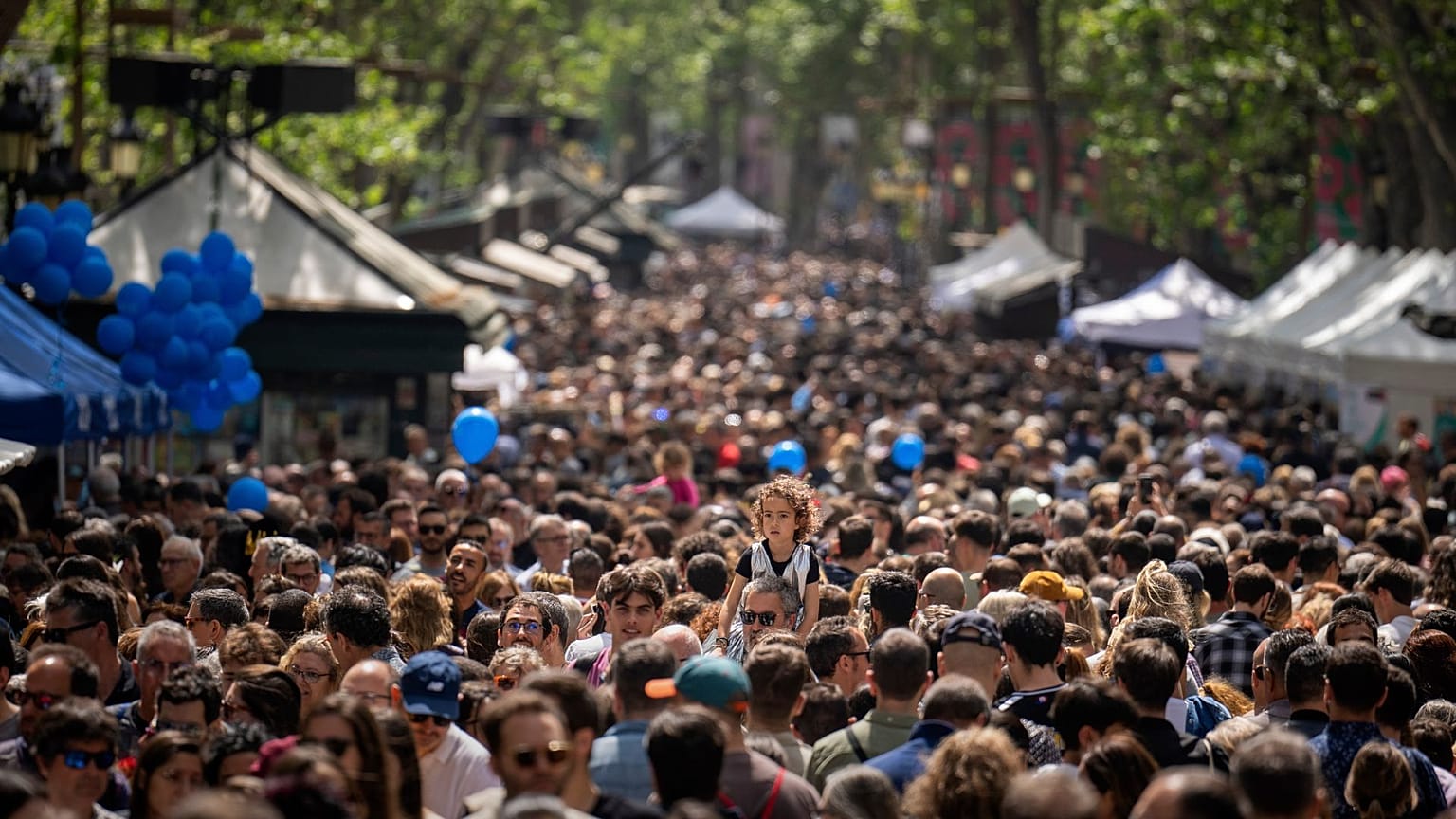 FILE - People crowd along the historic La Rambla promenade of Barcelona as Catalans celebrate the day of their patron Sant Jordi, Spain, Sunday, April 23, 2023. 