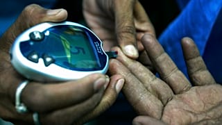 عاملة صحية، على اليسار، تأخذ عينة دم من يد مريض مصاب بالسكري في مخيم مجاني لفحص نسبة السكر في الدم بمناسبة اليوم العالمي للسكري في كلكتا، الهند، الجمعة 14 نوفمبر 2008