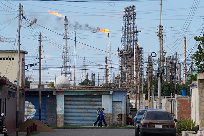 Flames rise from flare stacks at the Amuay refinery in Los Taques, 14 January, 2026