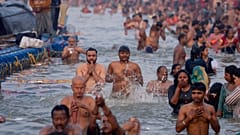 Hindu-Gläubige nehmen ein rituelles Bad am Sangam, dem Zusammenfluss von Ganges und Yamuna