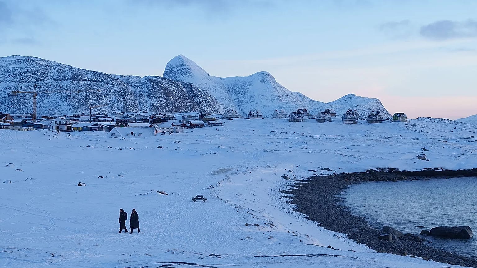 People walk on a beach in Nuuk, 15 January, 2026