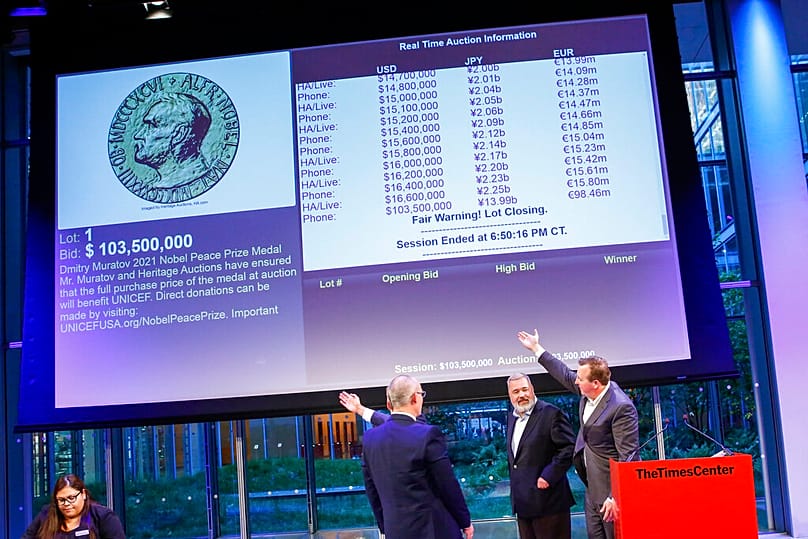FILE: People point to the screen showing the final price for Dmitry Muratov's 23-karat gold medal of the 2021 Nobel Peace Prize after being auctioned in New York 20 June 2022