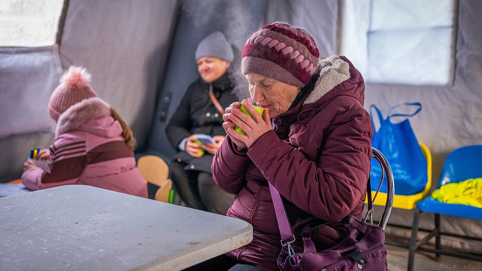 Una mujer entra en calor con una taza de té en un centro de emergencias habilitado para asistir durante los apagones provocados por los ataques aéreos rusos