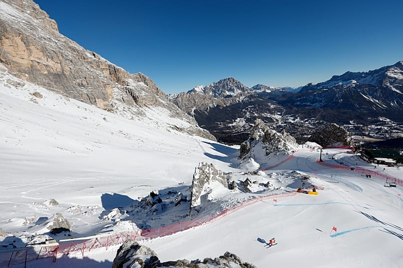 A skier is framed by the Dolomites landscape as she speeds down the Tofane course in Cortina d'Ampezzo, Italy.
