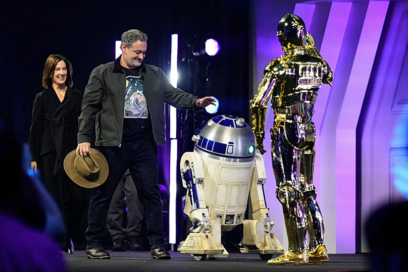 FILE: Kathleen Kennedy and director Dave Filoni meet R2-D2 and C3PO at a Star Wars fan convention in Chiba, near Tokyo, Japan, 18 August 2025