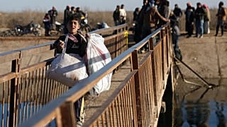 نازحون سوريون يسيرون للعبور عند معبر نهري بالقرب من قرية جريرات الإمام بريف حلب الشرقي قرب دير حافر، سوريا، الخميس 15 يناير 2026. 