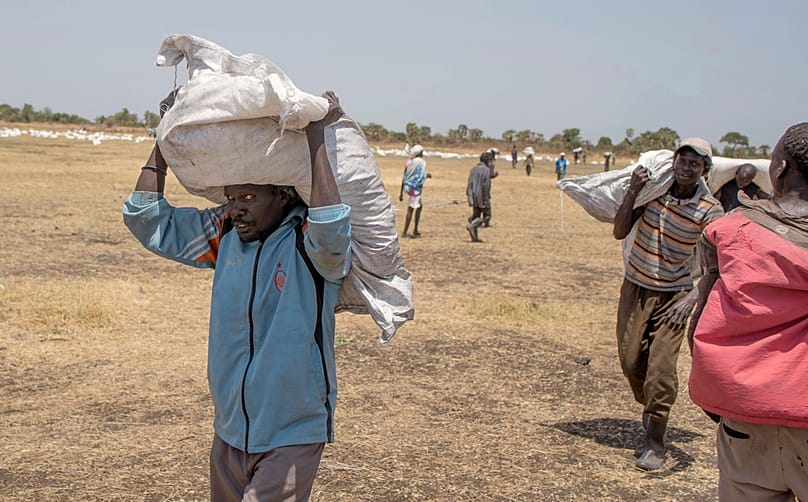 رجال من جنوب السودان يحملون مساعدات غذائية وزّعها برنامج الأغذية العالمي في مقاطعة لير بولاية لييك الجنوبية، في 6 مارس 2017.