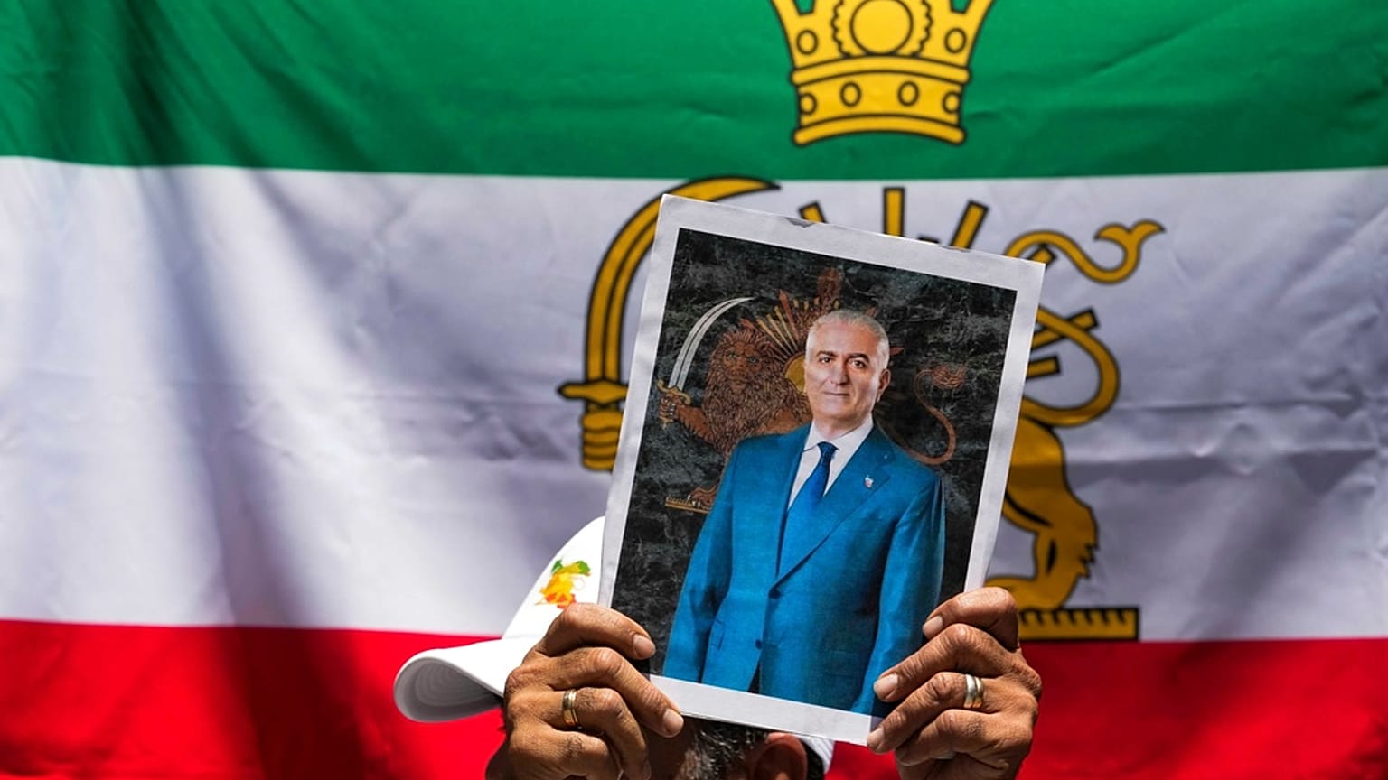 FILE: A protester holds a poster of Iran's exiled Crown Prince Reza Pahlavi during a rally outside Iran's embassy in Santiago, Chile, 13 January 2026