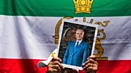 FILE: A protester holds a poster of Iran's exiled Crown Prince Reza Pahlavi during a rally outside Iran's embassy in Santiago, Chile, 13 January 2026