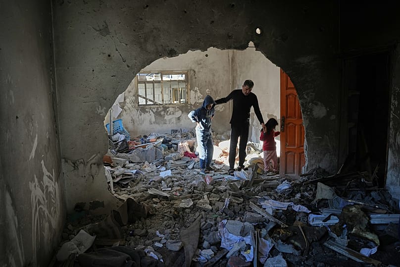 Palestinians inspect the rubble of the al-Hawli family home, destroyed in an Israeli strike in Deir al-Balah, in the central Gaza Strip, Friday, Jan. 16, 2026