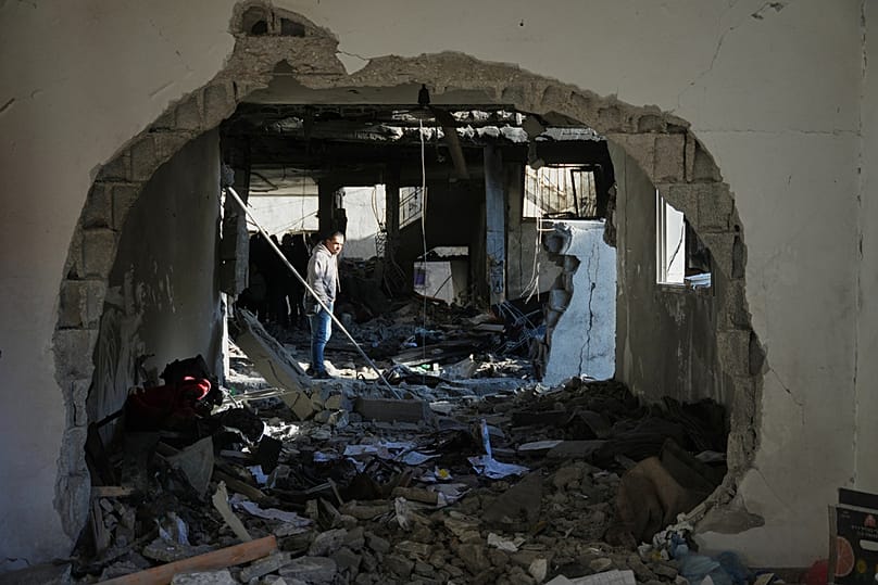 A Palestinian inspects the rubble of the al-Hawli family home, destroyed in an Israeli strike in Deir al-Balah, in the central Gaza Strip, Friday, Jan. 16, 2026