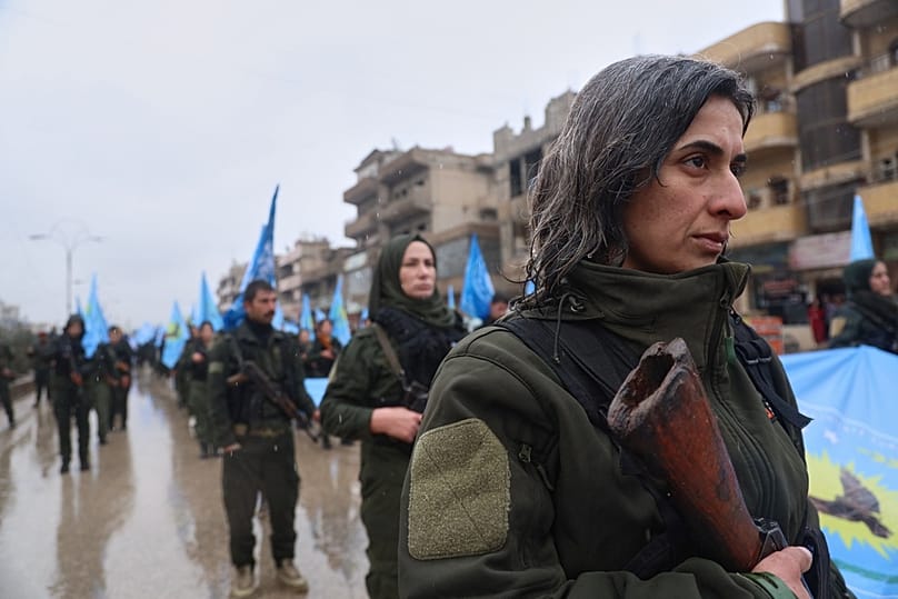 Female soldiers of the Kurdish-led, U.S.-backed Syrian Democratic Forces (SDF) march during a military parade in Qamishli, northeastern Syria, Sunday, Jan. 18, 2026.