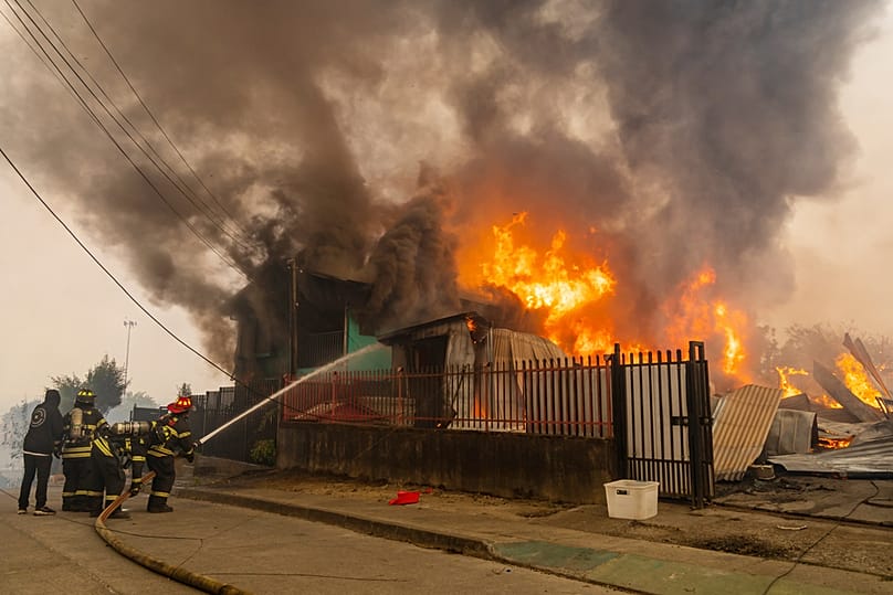 يصارع رجال الإطفاء حريقًا في أحد المنازل بينما تشتعل حرائق الغابات في ليركوين، تشيلي، يوم الأحد 18 يناير 2026. (صورة أسوشيتد برس / خافيير توريس)