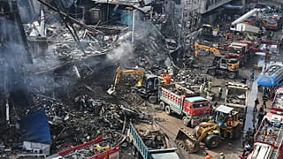 Rescue workers and firefighters work with heavy machinery to search through the rubble of a shopping plaza in Karachi, 19 January, 2026
