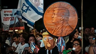 A man wearing a mask resembling US President Donald Trump holds a sign designed like a Nobel Peace Prize in Tel Aviv, 11 October, 2025