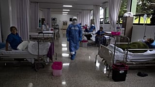 مرتديًا معدات الوقاية للحد من انتشار فيروس كورونا الجديد، يدخل الجراح العسكري، العقيد أوسكار بينافيدس أغيلار، جناحًا في مستشفى عسكري مُعد لرعاية مرضى كوفيد-19