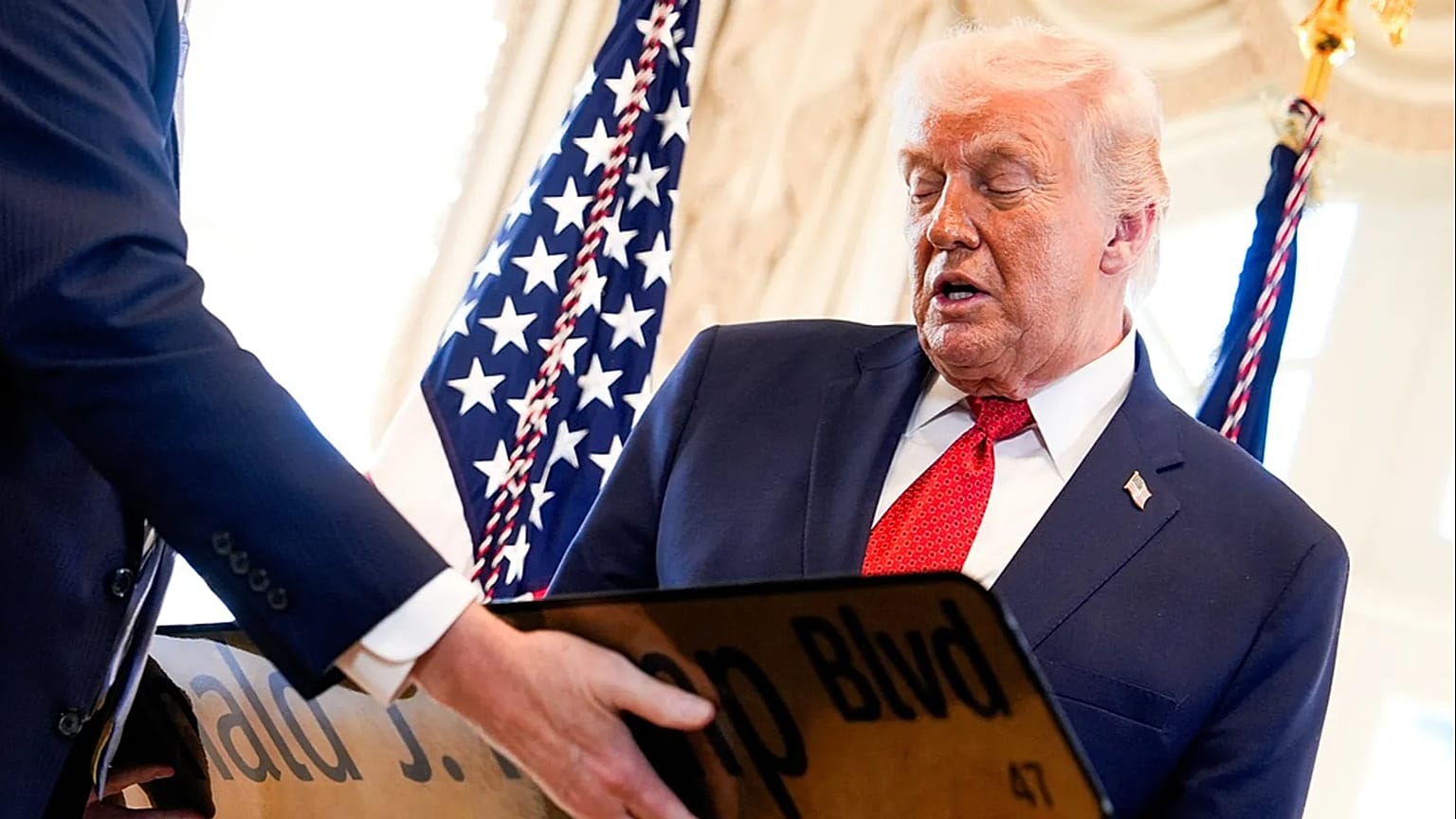 16 يناير 2026: دونالد  ترامب ينظر إلى لوحة إعادة تسمية شارع بالم بيتش إلى "بوليفارد الرئيس دونالد ج. ترامب".