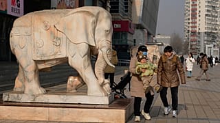 FILE. A woman lifts up a child in Beijing, China, on 15 Jan. 2026.