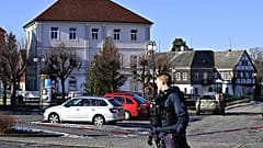 A police officer stands in front of the town hall in Chřibská, 19 January, 2026