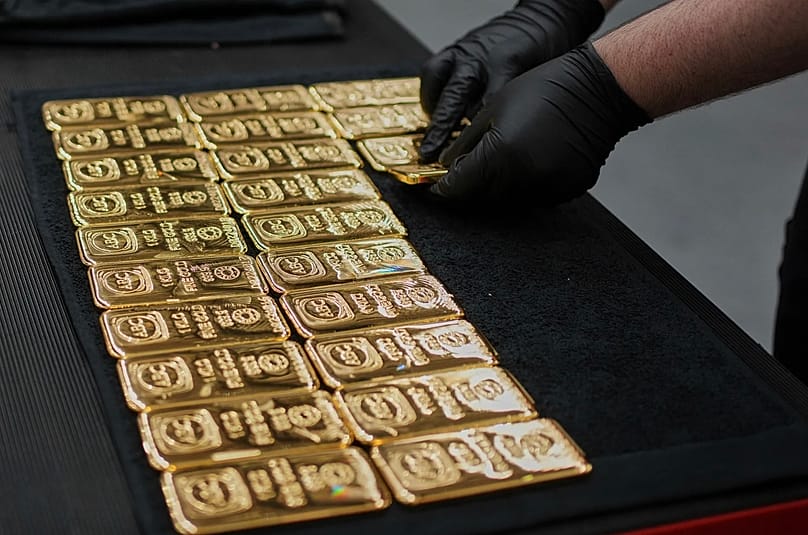 Sidney'deki ABC Rafinerisi'nde bir işçi, 1 kilogramlık altın külçelerini yerleştiriyor, 30 Nisan 2025.