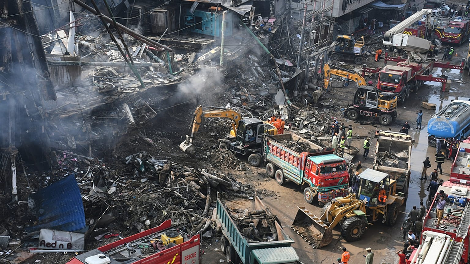 Karaçi'de ilk yardım ekipleri, yangın söndürme çalışmalarında.
